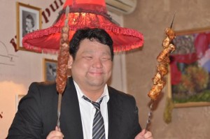 グルジア料理である串焼きを楽しむ社員